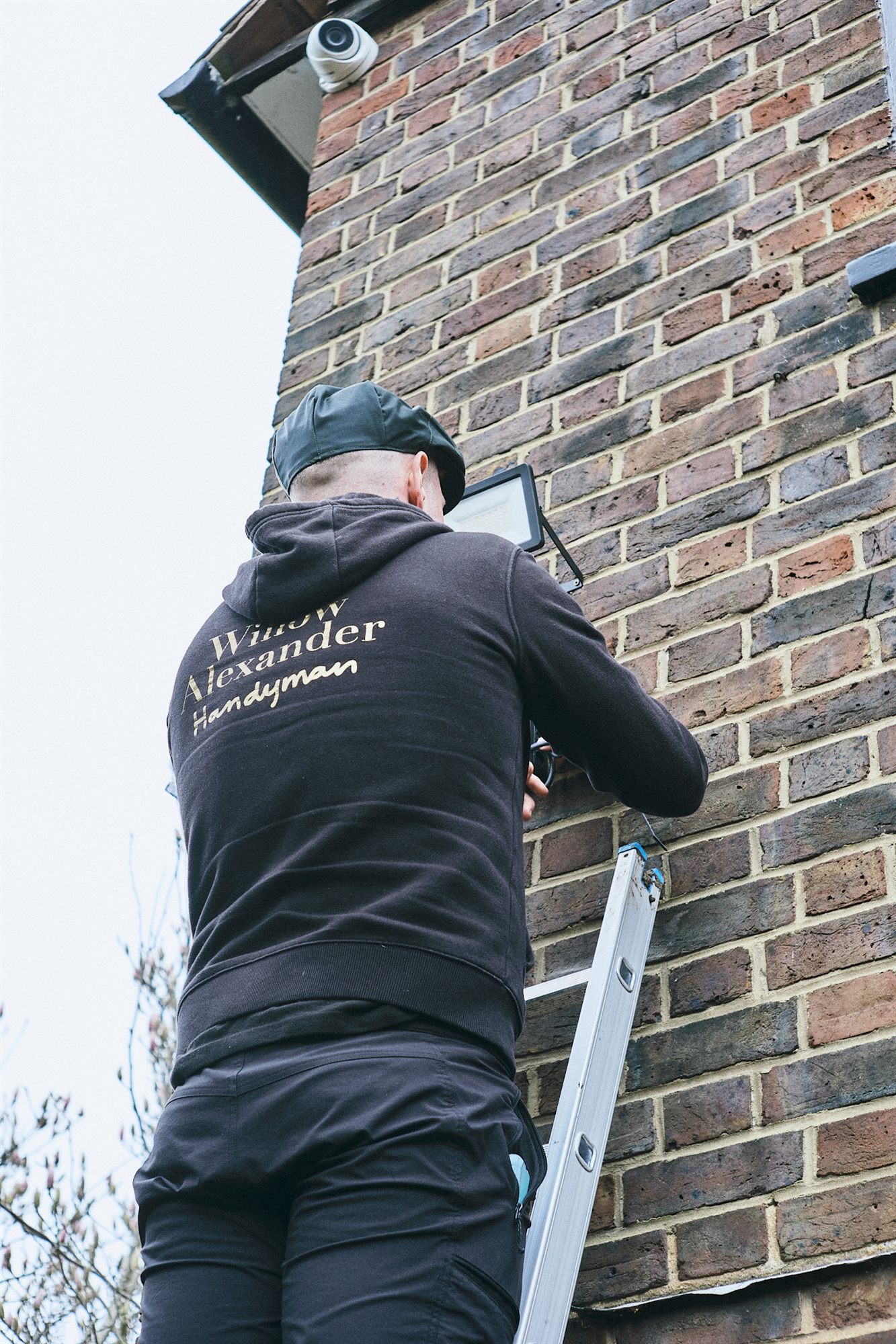 A Willow Alexander handyman working on a window and door frame