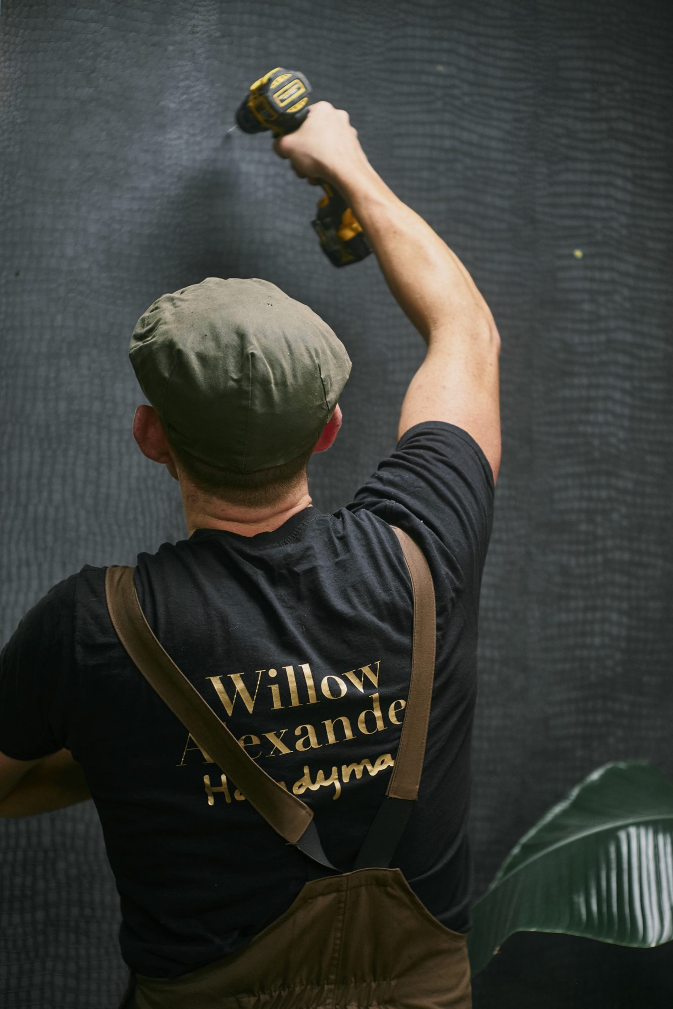 A Willow Alexander handyman drilling and fixing a mount to a wall